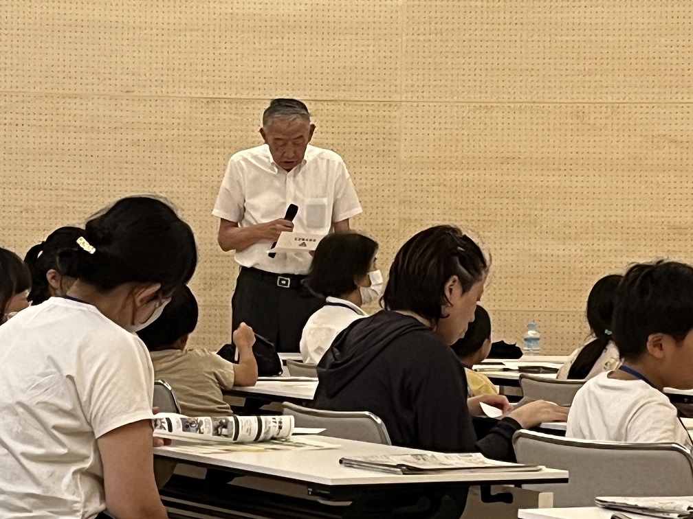 会議でマイクを持って話をする熊野町長を正面から捉えた写真