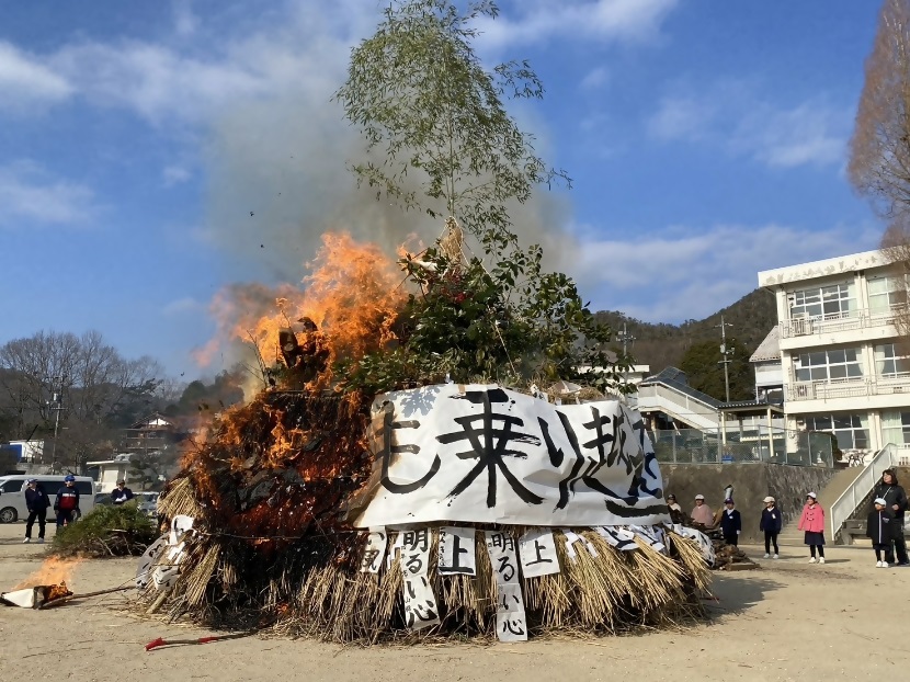 しめ縄や飾り物などが纏められた「とんど」に火を放ち、無常息災を祈る熊野町民の方々の写真
