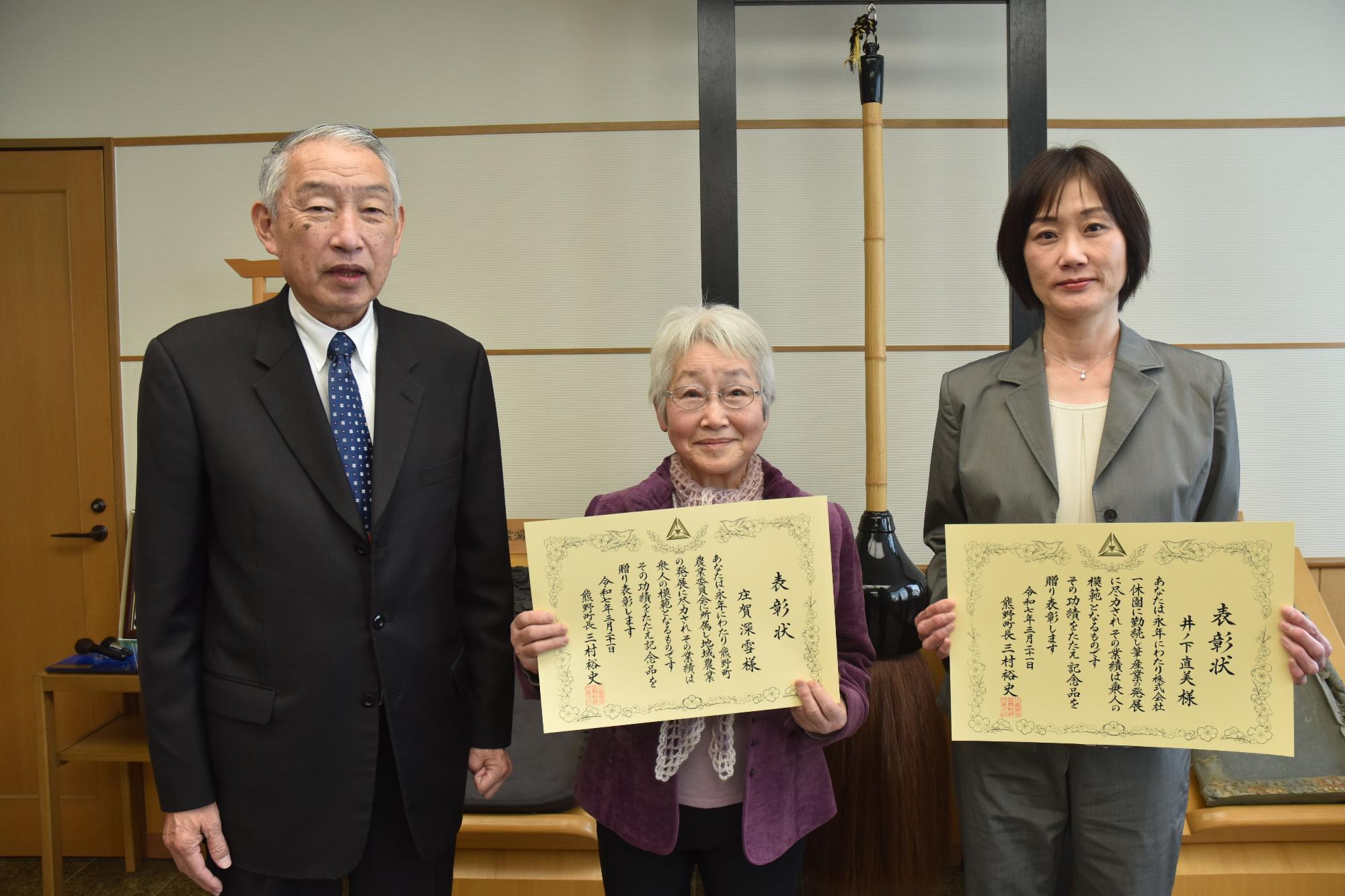 熊野町長といっしょに記念撮影に臨む庄賀さん、井ノ下さんの写真