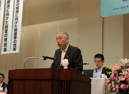 壇上でマイクに向かって話をしている熊野町長のアップの写真