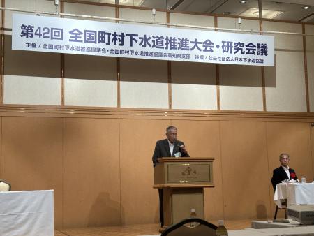 講堂の壇上でコメントを発表している熊野町長の写真