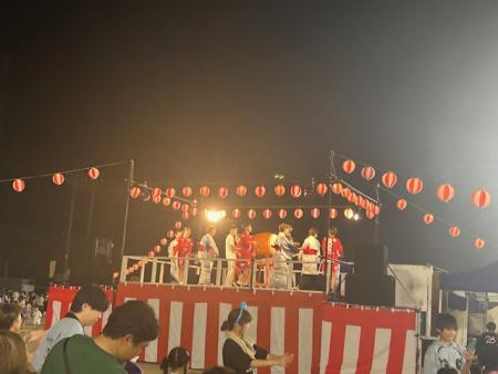 提灯が取り付けられた櫓の上で盆踊りを踊る町民の方々の写真