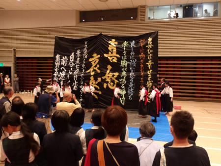 熊野町民会館のホールで大作席書を披露する熊野中学校書道部の皆さんの写真
