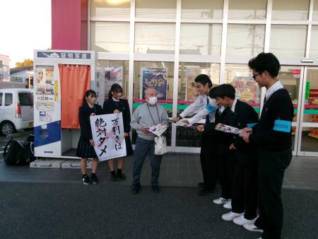 ドラッグストアコスモス熊野店で「万引きは絶対ダメ」という標語を持ちながら防犯キャンペーンに参加する熊野高校の生徒の皆さんの写真