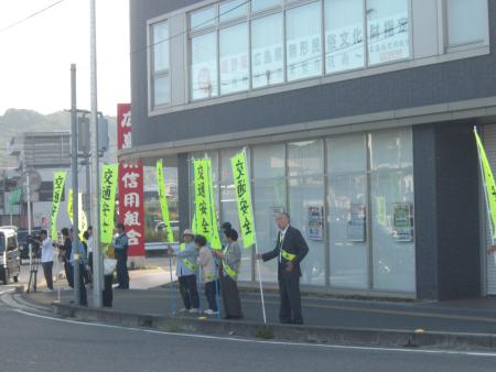 「交通安全」ののぼりを持ちながら、交差点で交通安全を呼び掛けている方々の写真