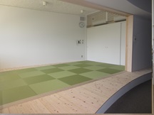 引き戸のレールの奥に緑色の床がある和室の写真