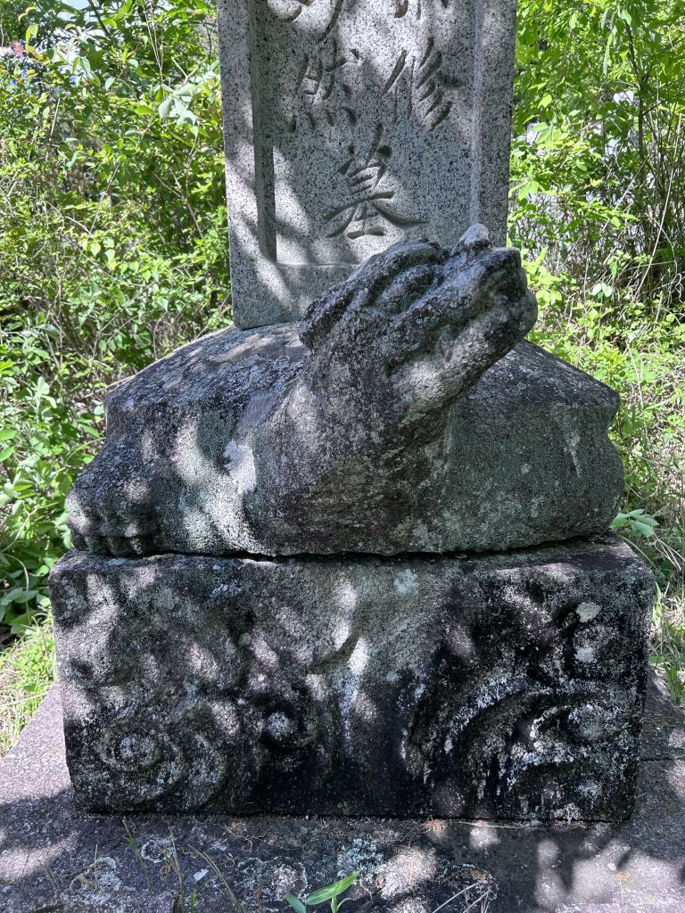 墓石の前面に亀の首の彫刻があしらわれているお墓のクローズアップ写真