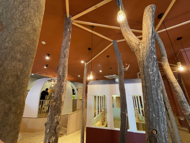 四角形や円形のブースあり、木の柱が並んでいるおもちゃ美術館の写真