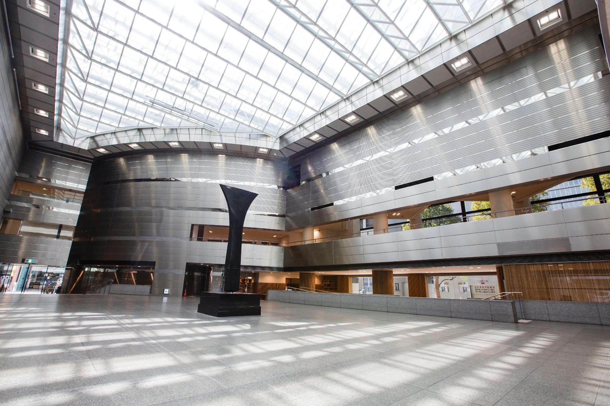 ガラス張りの採光性の良い天井がある美術館の吹き抜けホールの写真