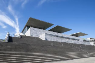 特徴的な屋根の庇をもつ美術館の外観の写真