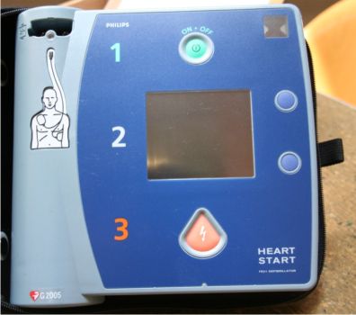 中央にモニターが付いた青色のAED機器の写真