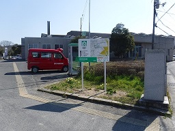 建物の前のスペースに案内板が設置されている写真