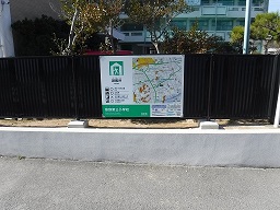建物を囲っているフェンスに案内板が取り付けられている写真