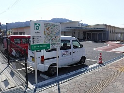 建物前の駐車場と歩道の間に案内板が設置されている写真