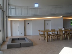 広いフロアの窓側にマットとテーブル・椅子が置かれている写真