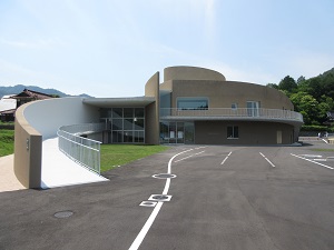 駐車場と隣接している灰色の建物の写真