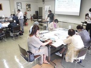 組となって机で作業する人々の写真