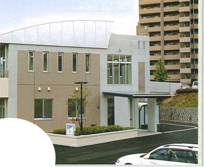 薄茶色の建物と遠くに高層マンションが見える写真