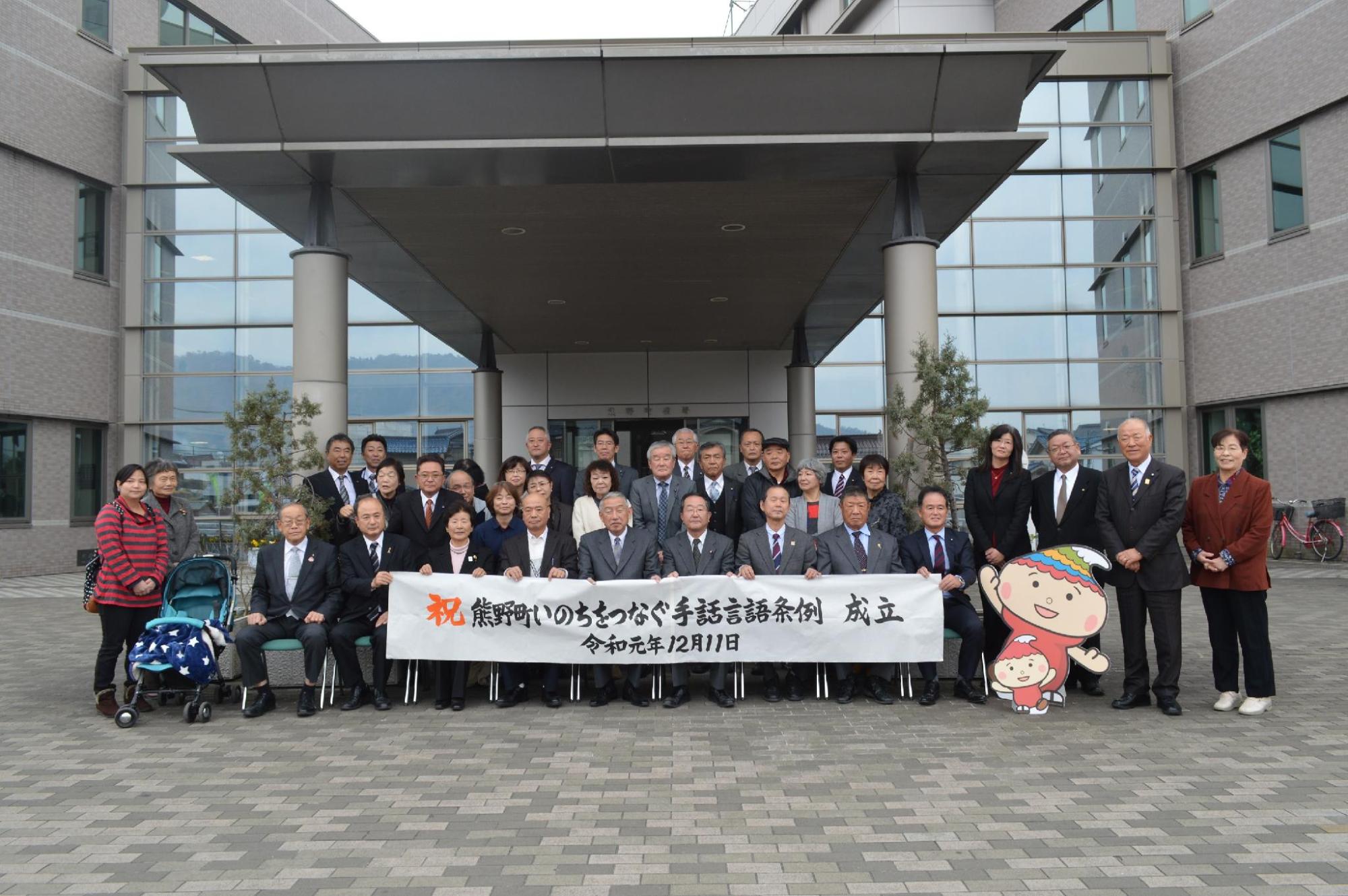条例制定の記念撮影で、熊野町庁舎前で記念撮影に臨む熊野町長ら町職員の写真