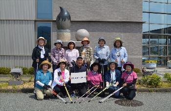 外で大人たちが集合写真を撮影している写真