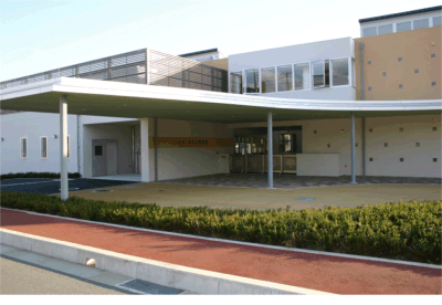 白とオレンジを基調としたくまの・みらい保育園の正面玄関の外観写真