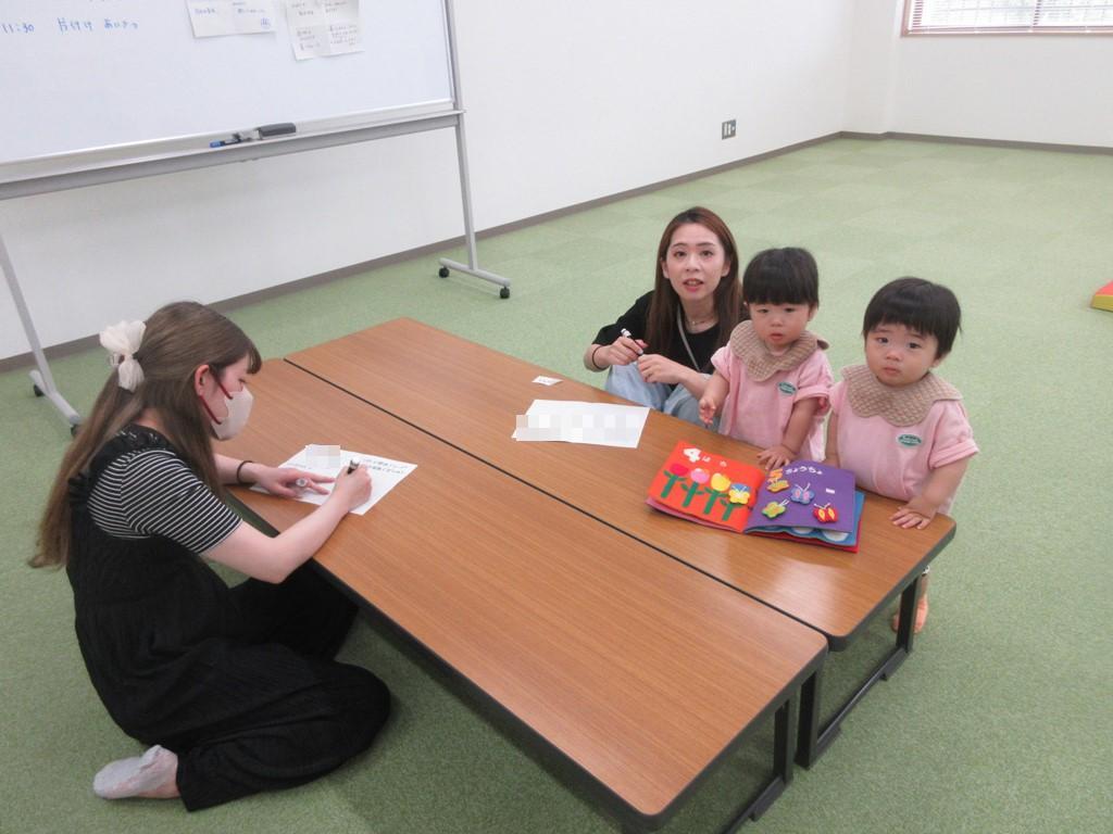 お絵描きをする双子と母の様子