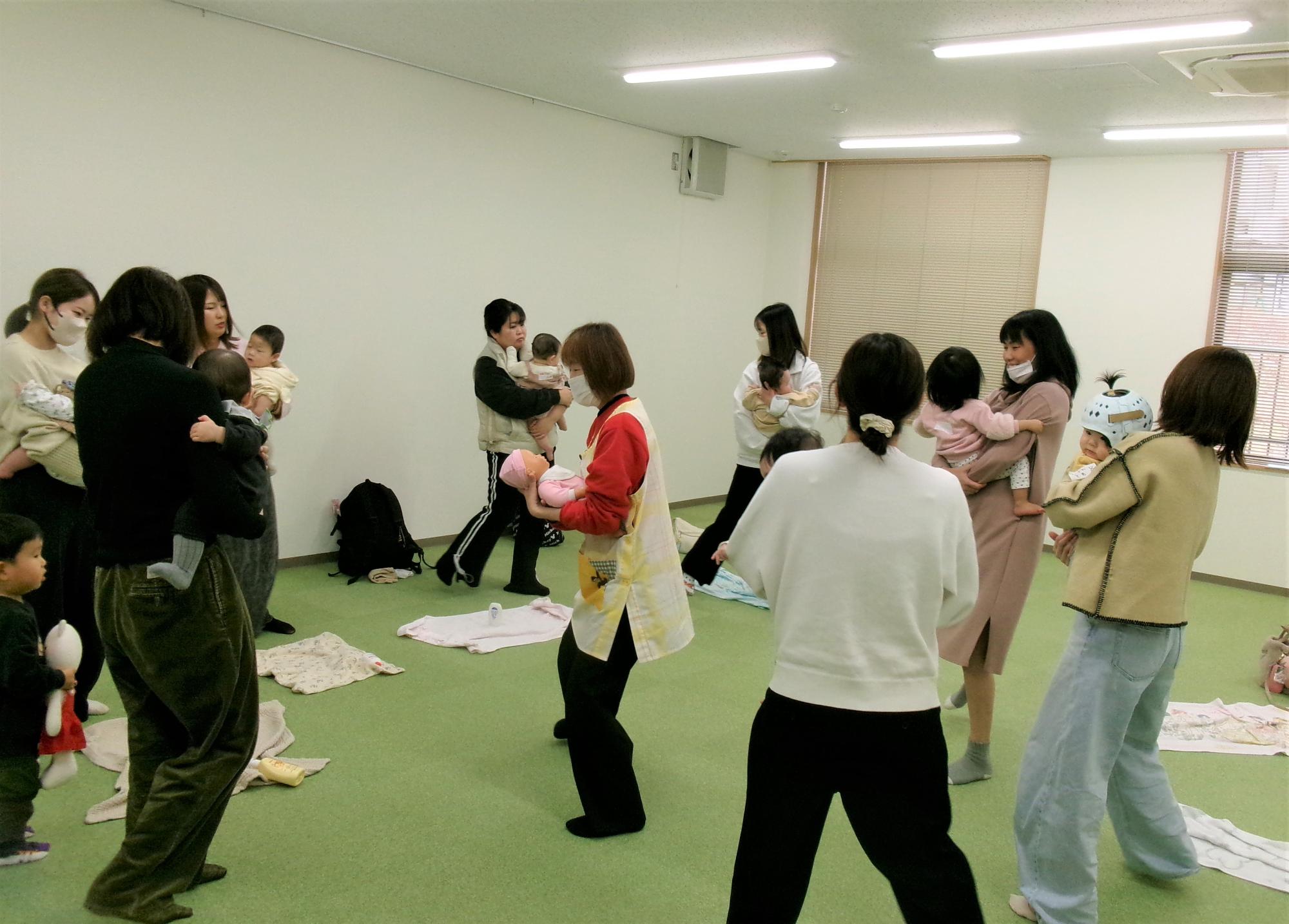 お母さんが赤ちゃんを抱っこしてリズムに乗っている写真