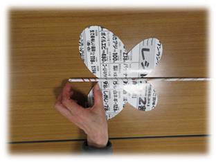 切り抜かれたチラシに紙の棒を置いている写真