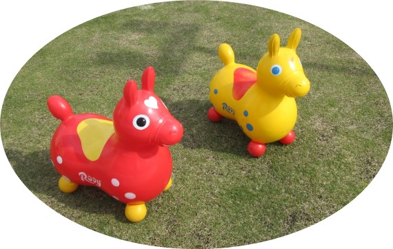 赤と黄色をした馬型の遊具が置かれている写真