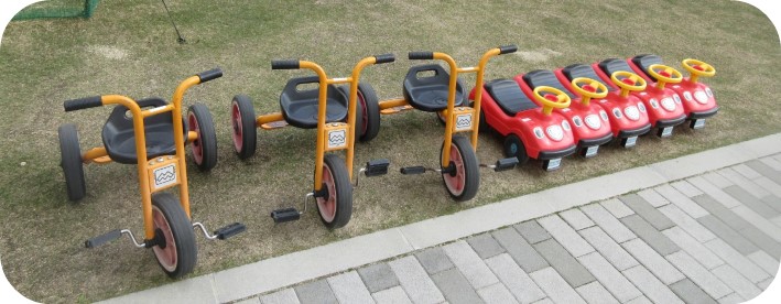 三輪車・車型の乗り物が並べて置かれている写真