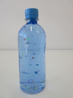 水の入ったペットボトルに色とりどりのラメが入っている写真