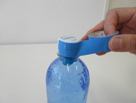 ペットボトルの蓋に水色のテープを巻きつけている写真