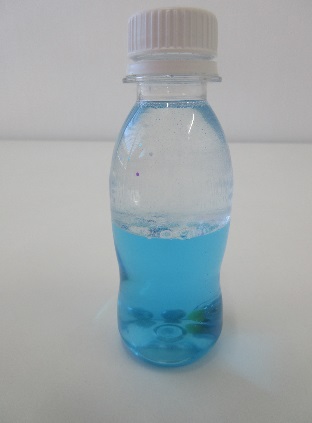 上半分に透明の水、下半分に薄い青色の水が入っているペットボトルの写真