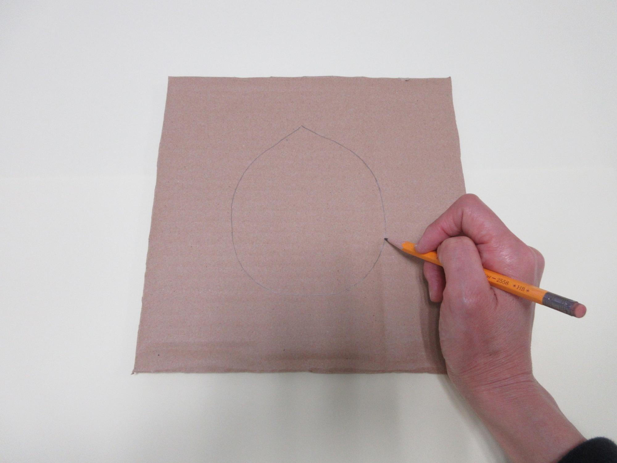厚紙に鉛筆で丸を描いている写真