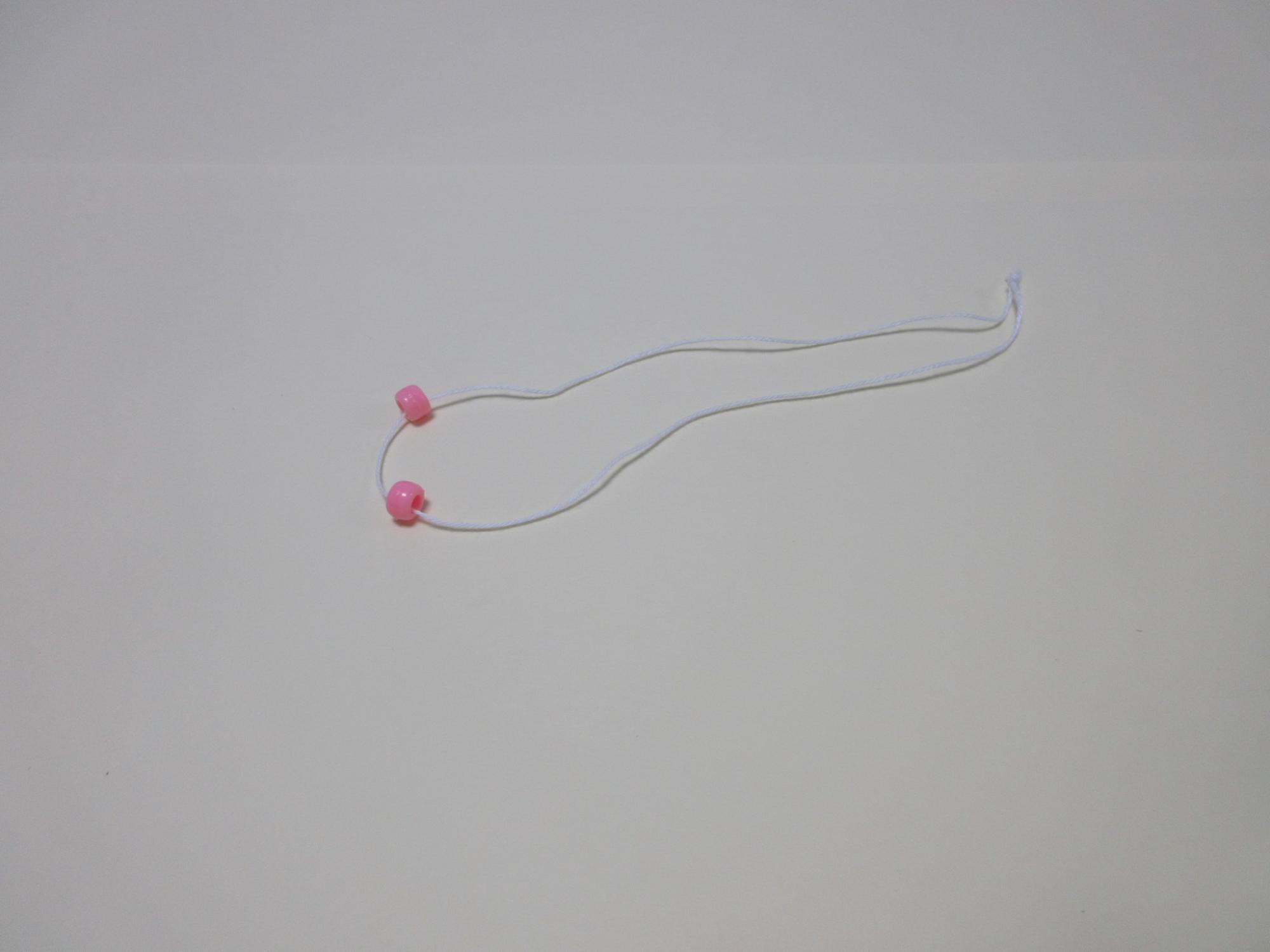 紐にピンク色のビーズが2つ通っている写真