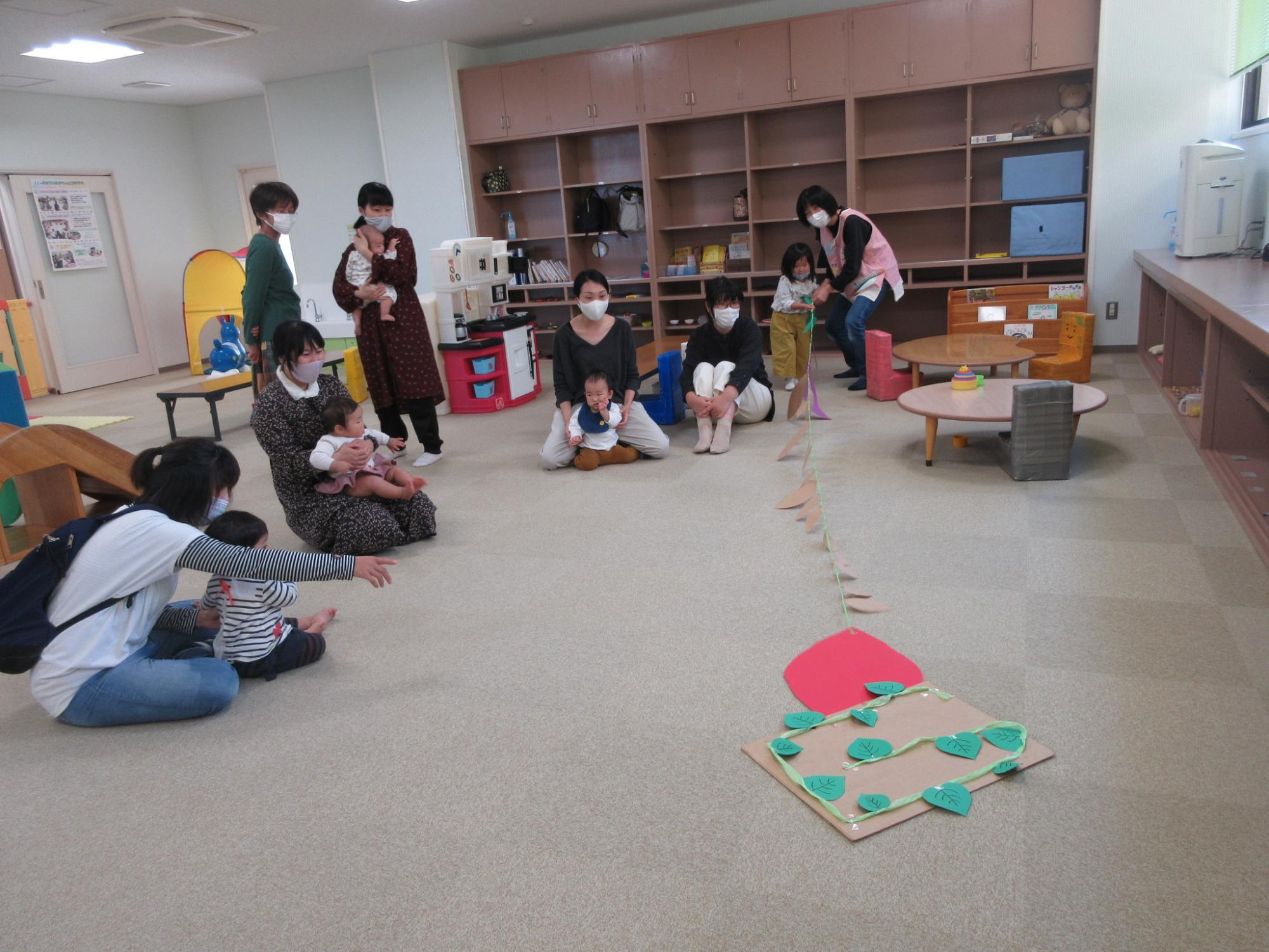 紐で繋がった工作を引っ張っている子供の写真