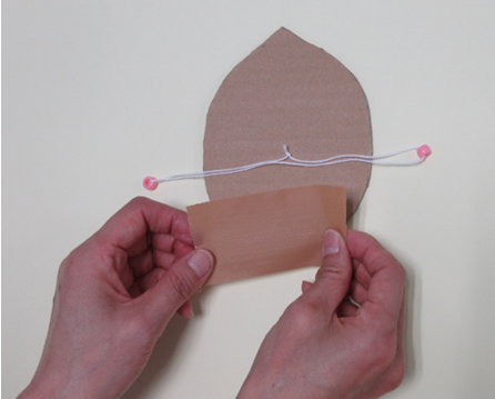 丸く切られた厚紙にガムテープを付けている写真