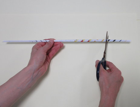 細長く巻かれた紙にハサミを入れている写真