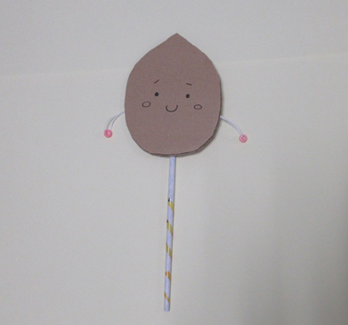 顔の描かれた厚紙に細長い紙や紐が付けられている写真