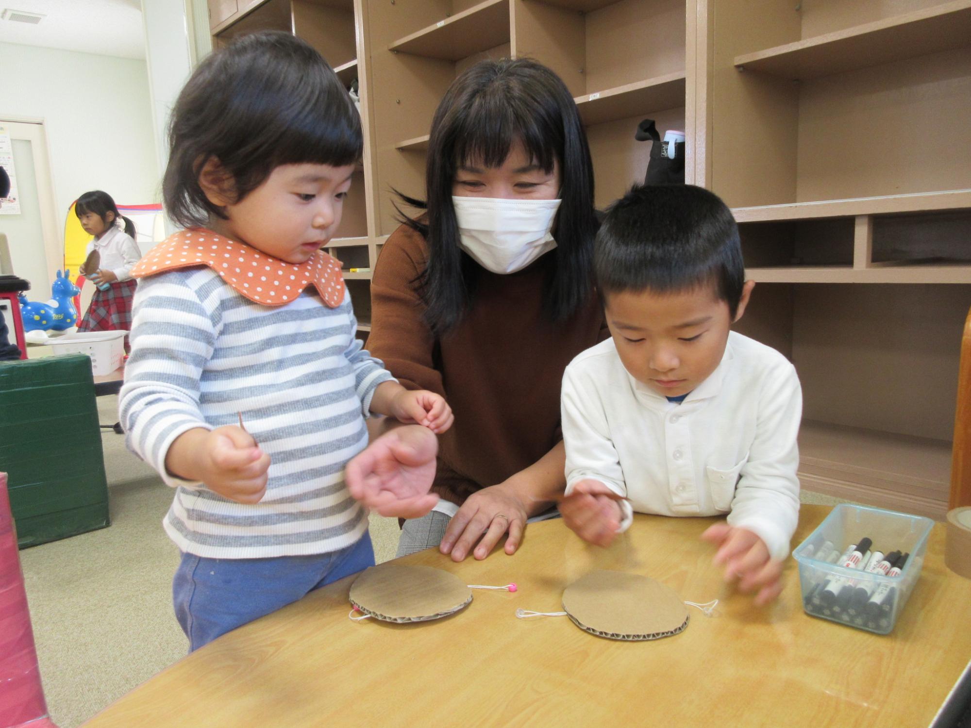 テーブルの上で工作をしている親子の写真