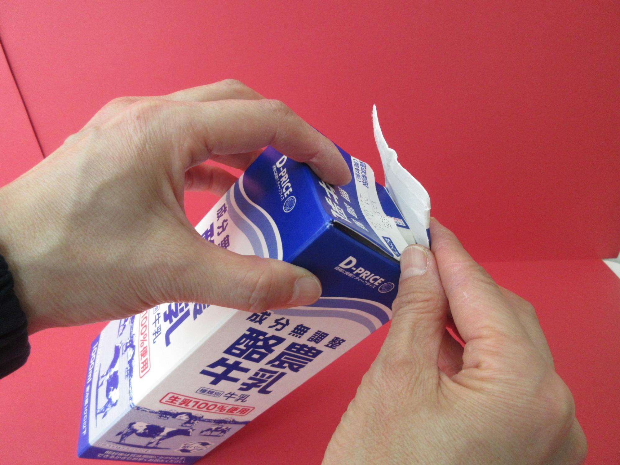 牛乳パックの蓋を閉めようとしている写真