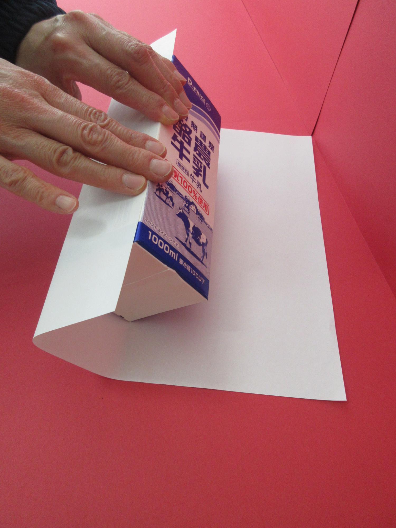牛乳パックに白い紙を巻いている写真