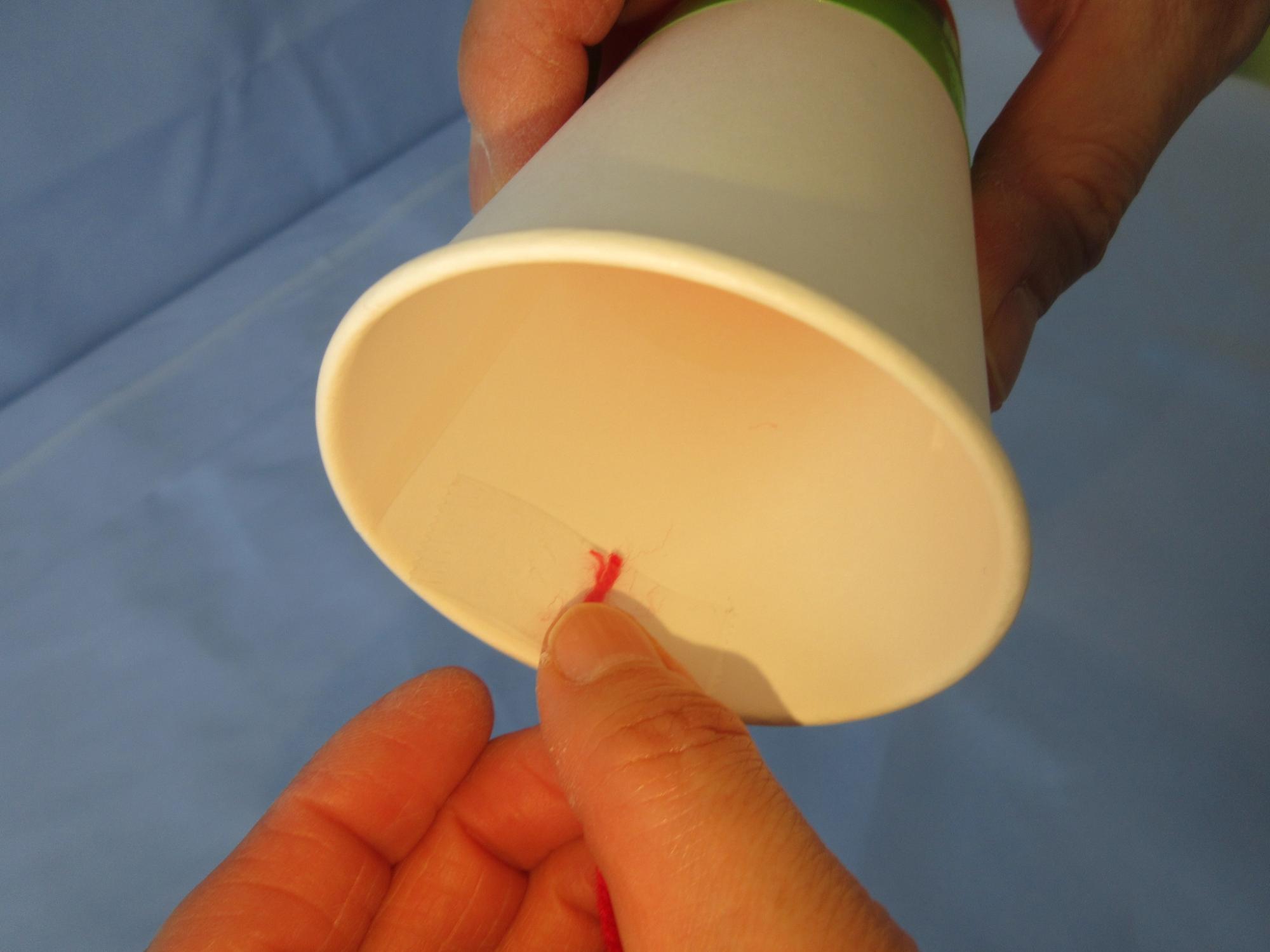 紙コップのふちに赤いひもをくっつけている写真