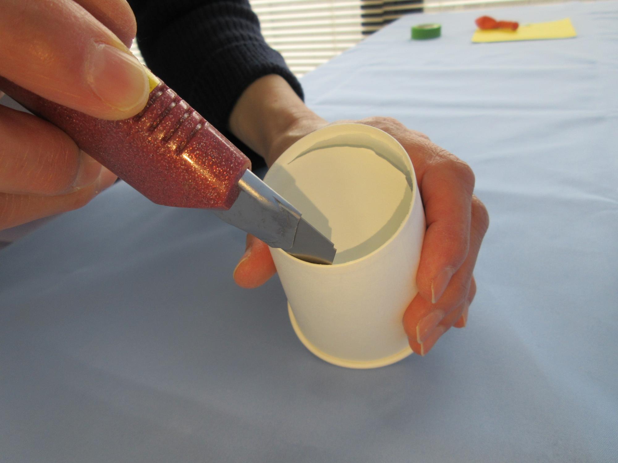 紙コップの底をカッターで切っている写真