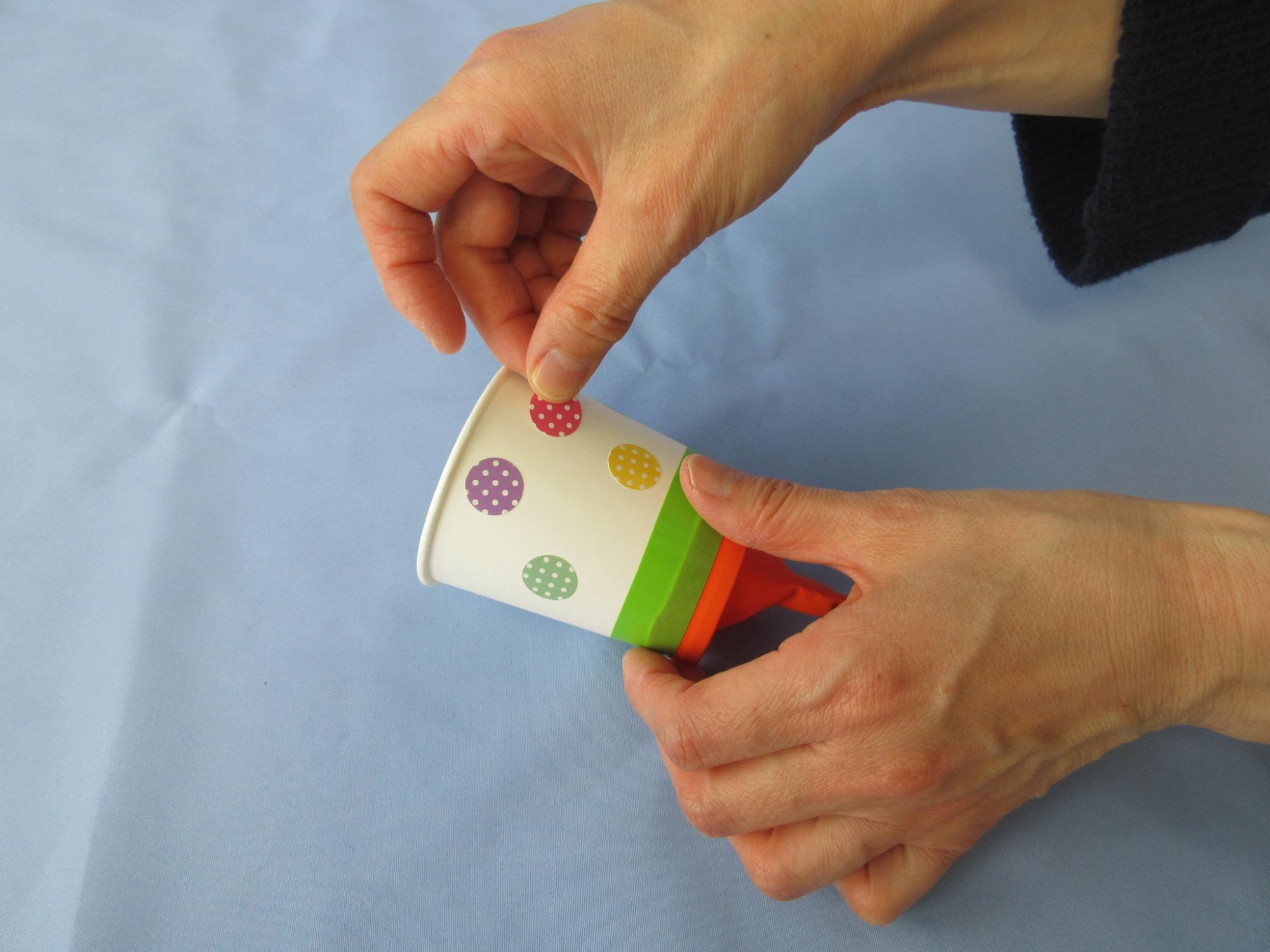 紙コップに水玉模様のシールを貼っている写真