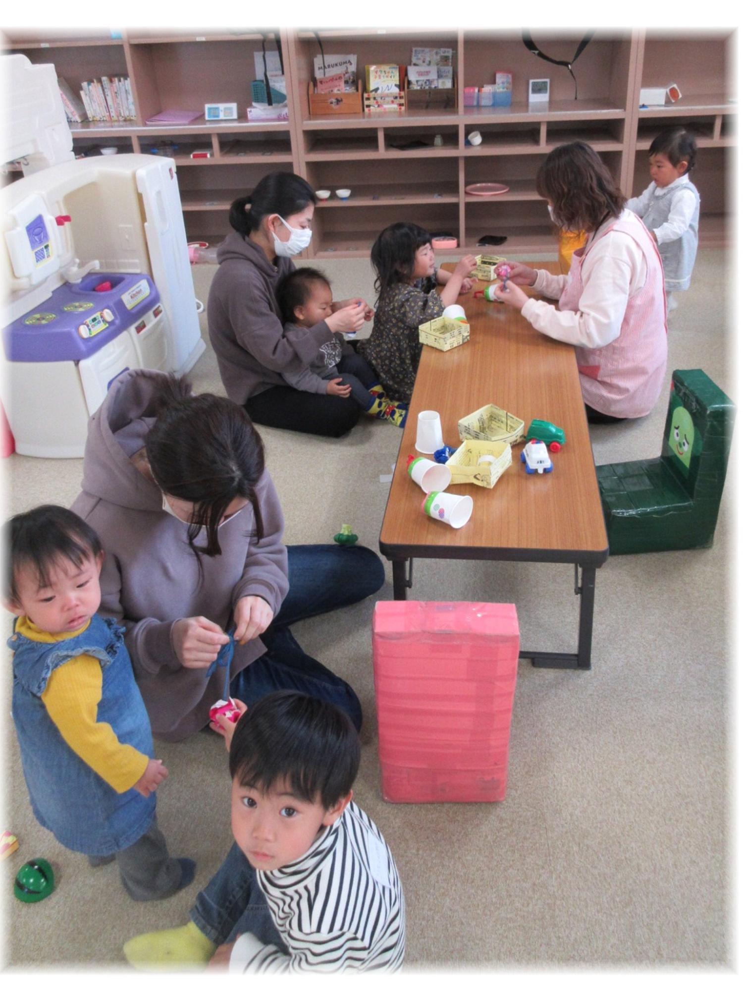 テーブルなどで工作をしている人たちの写真