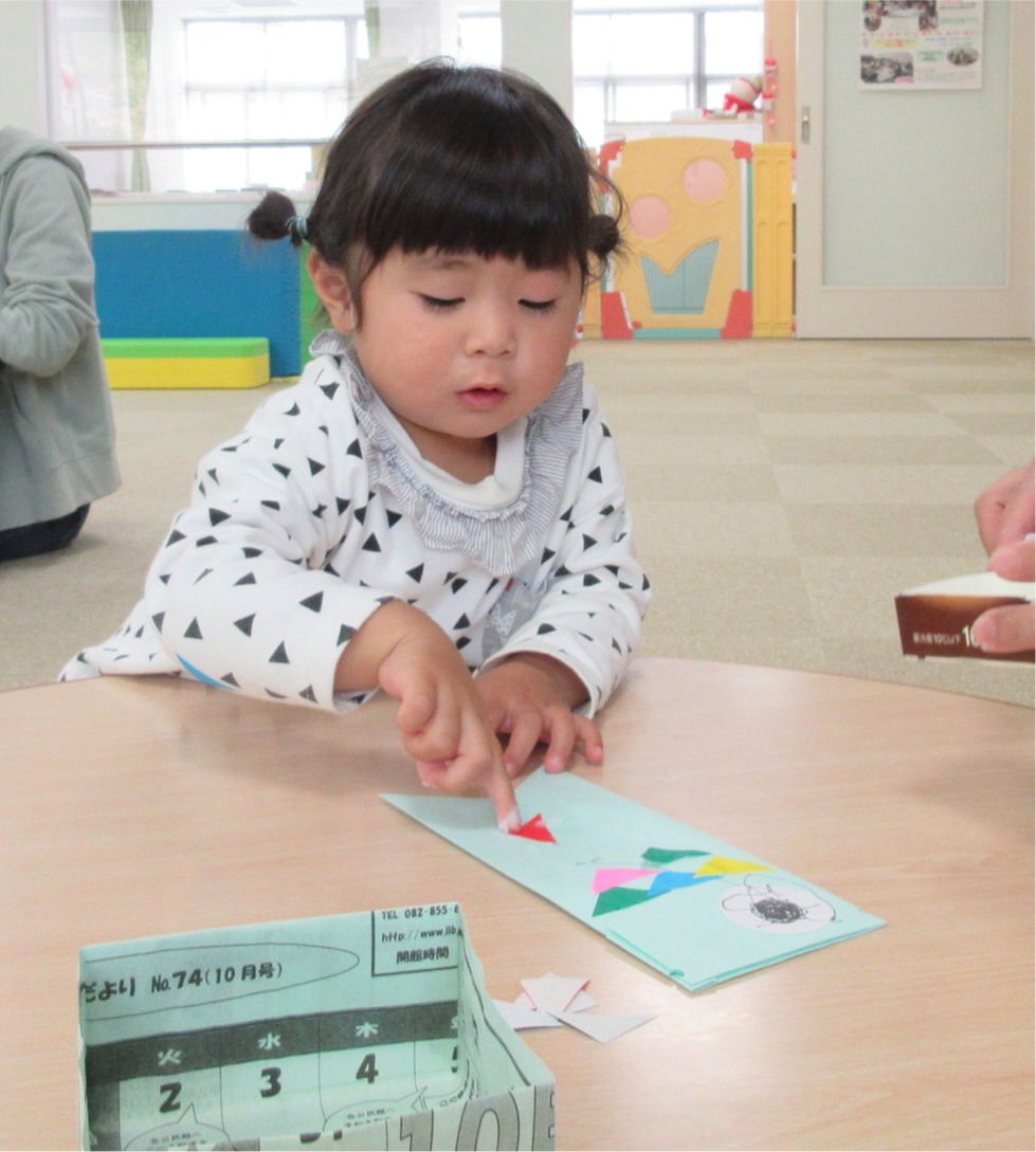 台紙に切った紙を貼る子供の写真