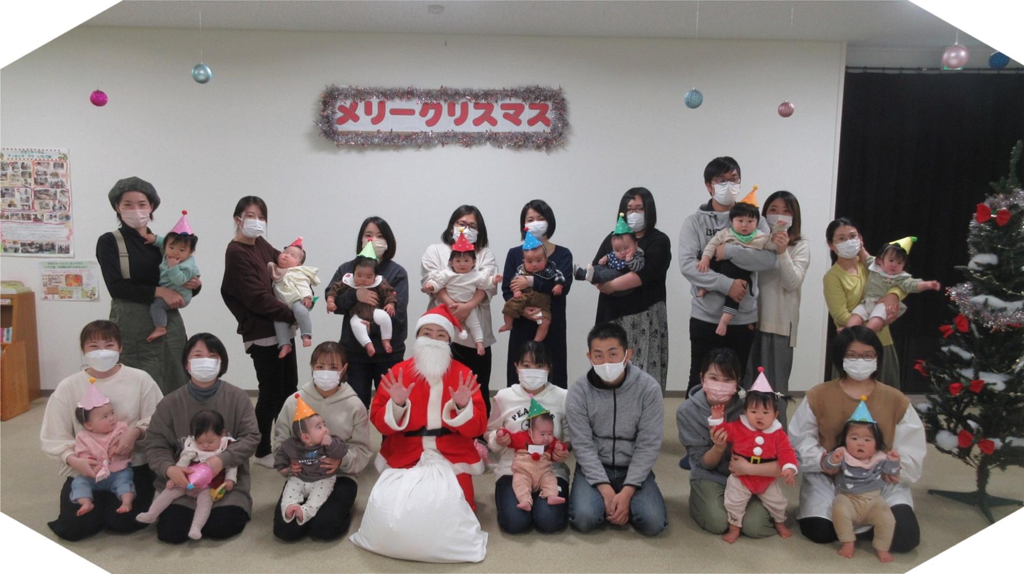 サンタと親子達が並んでいる写真