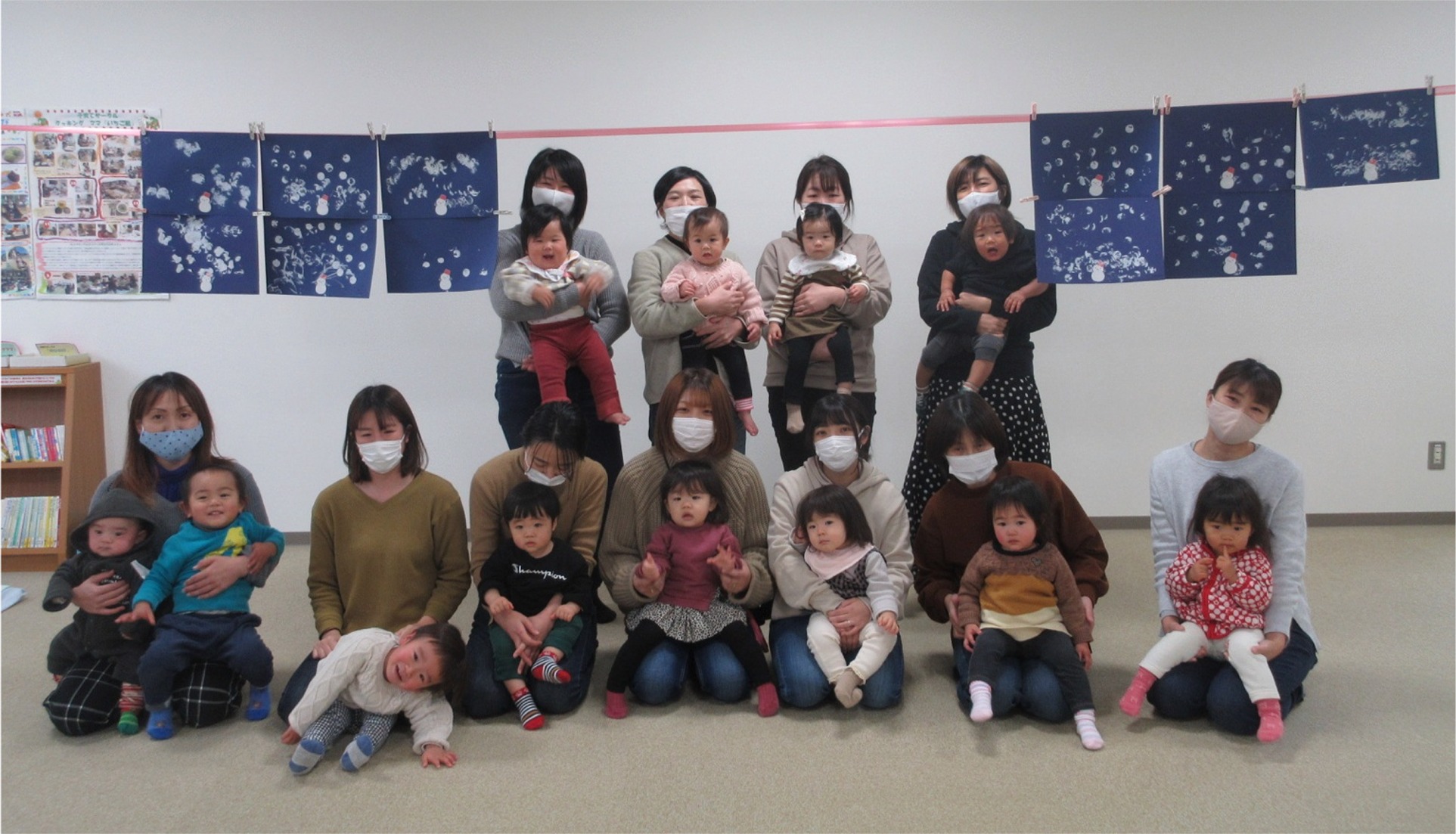 女性達が子供を抱いて並んでいる写真