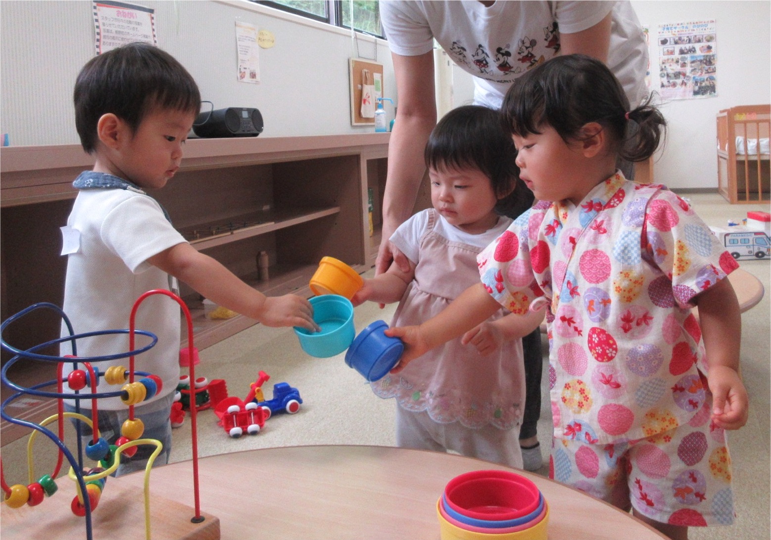 玩具のカップで遊ぶ子供達の写真